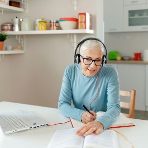 Woman studying on computer with headphone