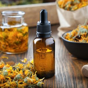 Tincture bottle surrounded by yellow flowers
