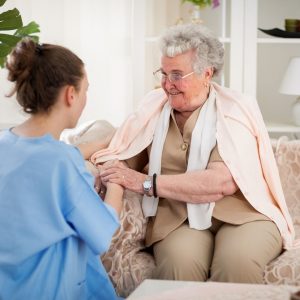 Home health aide assists smiling older woman