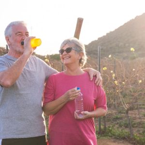 Older couple hydrating while on a walk in the evening