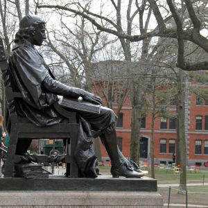 Profile photo of Brass statue, seated figure with one foot extended.