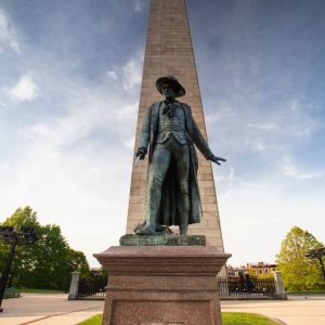Statue in front of a granite obelisk