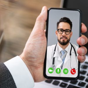 a hand is holding a phone with a Doctor in a white lab coat on Facetime