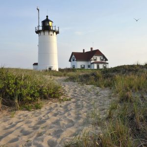 a historic lighthouse is lit by sunset 