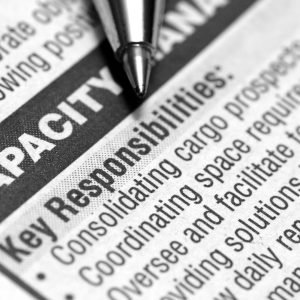 Close-up of a job posting in the newspaper, describing the key responsibilities in vague terms