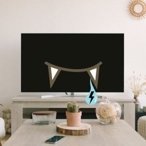 In a nicely furnished living room, a TV is turned off but has cartoonish vampire teeth. A droplet is hanging off one fang, with a lightning bolt symbol on it