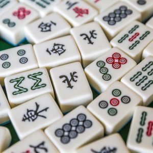Close-up image of Mahjong tiles, which are white, plastic domino-esque blocks. They have chinese characters and images printed on them.