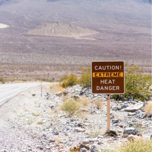 A sign in the high desert reads "Caution: extreme heat danger"