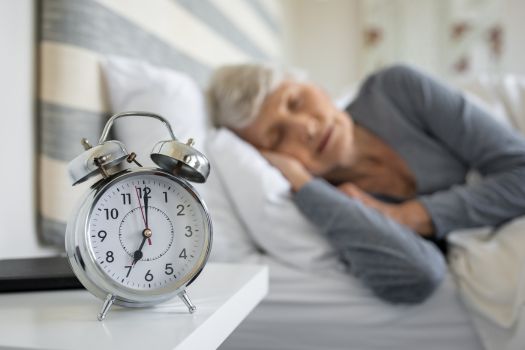 Woman sleeping next to alarm clock