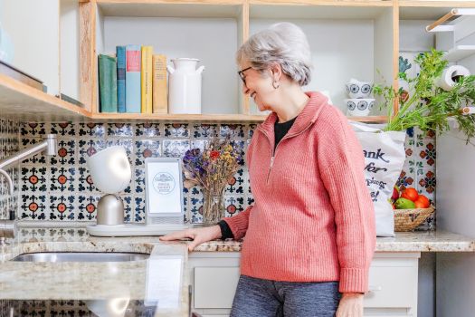 Senior interacts with ElliQ in her kitchen