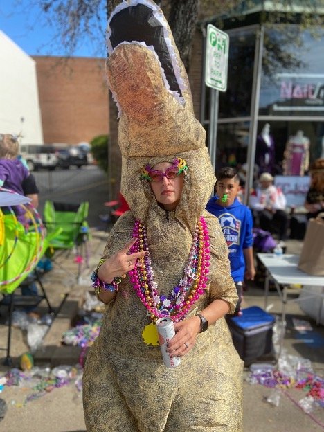Writer Caitlin Manner celebrating Mardi Gras in an inflatable T. rex costume.