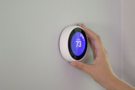 smart thermostat being adjusted