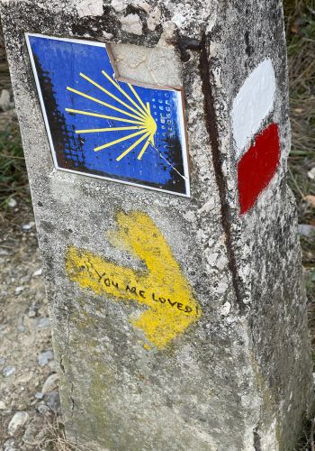 A sign marked with the signature scallop shell on the Camino de Santiago.