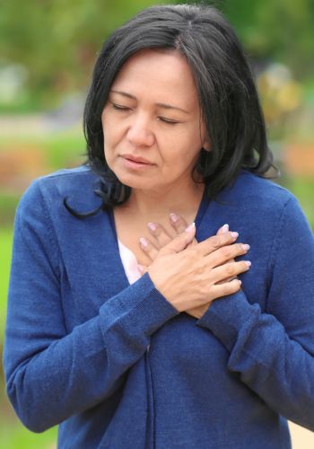 Woman clutching chest in distress