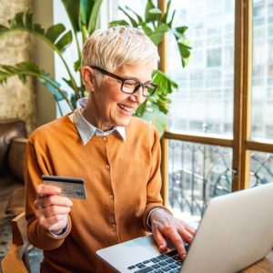 senior uses credit card to make online purchase