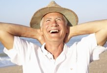 Summertime Hacks for the Best Beach Day Senior man relaxing on beach, looking toward sunny sky