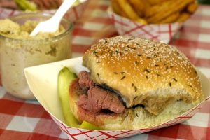 Photo of a Beef of Weck sandwich on a red and white checkered table