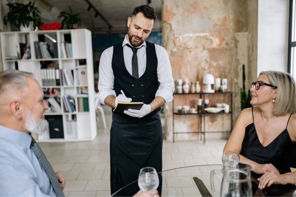 senior couple places food order with waiter