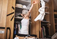 Beyond the Closet Purge: Building a Wardrobe That Fits Your Life Now Woman reorganizing her closet_declutter your closet featured image