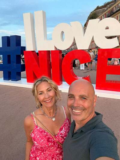 Alison Michael and husband standing in front of "I Love Nice" sign in France